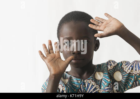 Afrikanisches Kind sein Gesicht mit den Händen schützen, isoliert auf weißem Stockfoto