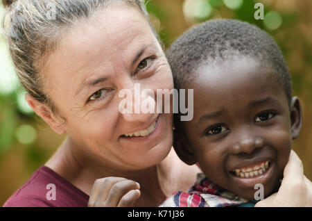 Wunderschöne Frau erhält ein Portrait mit einem schwarzen Baby, das sie adoptiert Stockfoto