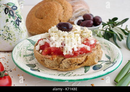 Dakos traditionelle Geek Aperitif auf einer traditionellen Platte mit keramischen Olivenöl jar, trockenen Roggen Brot, Oliven und Olivenöl. Gesunde Ernährung Konzept. Mediterrane Lebensart Stockfoto