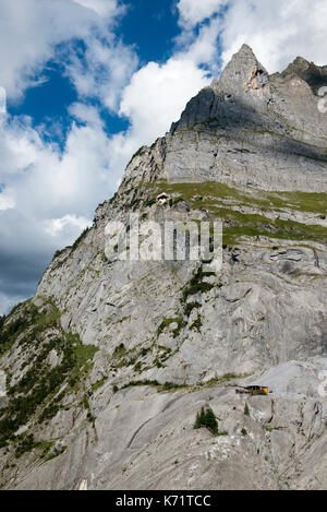 Zwei Hütten eingebettet in die Felswand des Wetterhorn über Schwarze Lütschine, Grindelwald, Schweiz Stockfoto