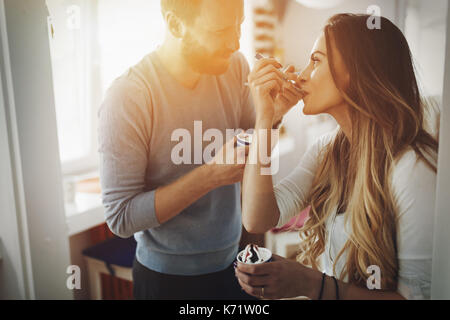 Paar Spaß zu haben und zu Hause lacht während Eis essen Stockfoto