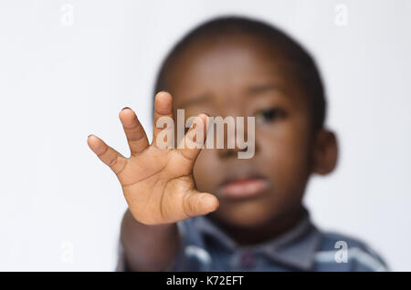 Afrikanischen Jungen seine Hand als ein Stoppschild für Rassismus und Missbrauch Stockfoto