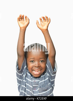 Kleinen afrikanischen Jungen die Hände hoch in die Luft und Lachen und Lächeln Stockfoto