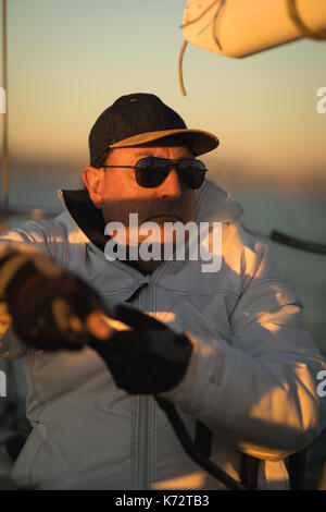 Yachtsman sitzen auf dem Boot bei Sonnenuntergang Stockfoto