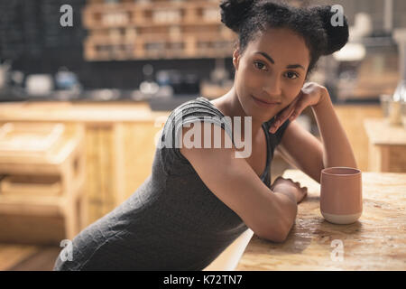 Schöne Frau sitzen in cafÃƒÂ© mit Kaffee auf Tisch Stockfoto