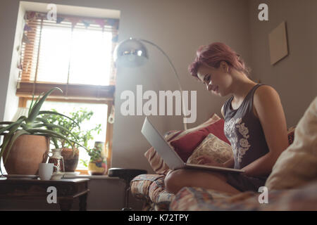 Entspannt junge Frau mit Laptop auf dem Sofa zu Hause Stockfoto