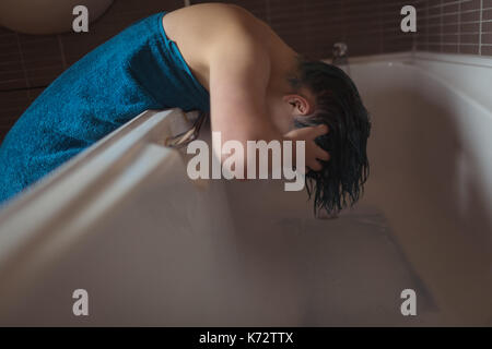 Seitenansicht der Frau Haare waschen in der Badewanne zu Hause Stockfoto