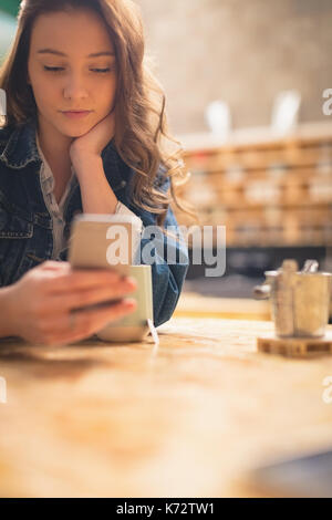 Schöne Frau mit Handy in CafÃƒÂ © Stockfoto