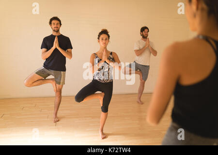 Yoga Lehrer die Schüler dabei die Baumhaltung bei Yoga Studio Stockfoto