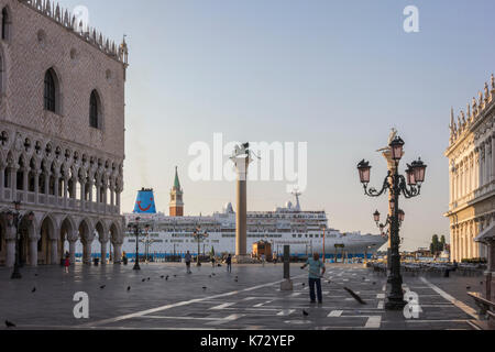 Ein Kreuzfahrtschiff ist vorbei an der Piazza San Marco in Venedig, Italien, am frühen Morgen im Sommer. Auf der linken Seite ist der Dogenpalast. Stockfoto