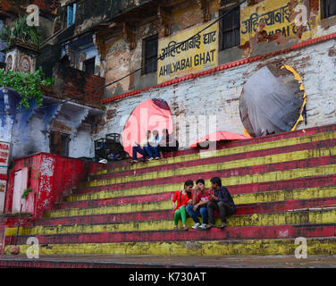 Varanasi, Indien - May 11, 2015. Die Jugendlichen sitzen auf den ghats, Böschungen, in Schritten von Steinplatten entlang des Ganges River Bank, wo Pilger pro Stockfoto