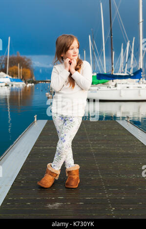 Portrait von kleines Mädchen in einem kleinen Hafen, tragen weiße Fleece Jacke Stockfoto