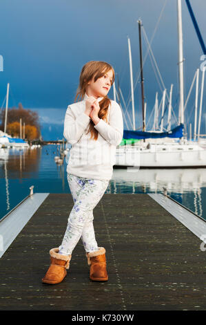 Portrait von kleines Mädchen in einem kleinen Hafen, tragen weiße Fleece Jacke Stockfoto