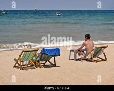 Mann allein am Strand. Pattaya Thailand Südostasien. Menschen Einsamkeit. Stockfoto