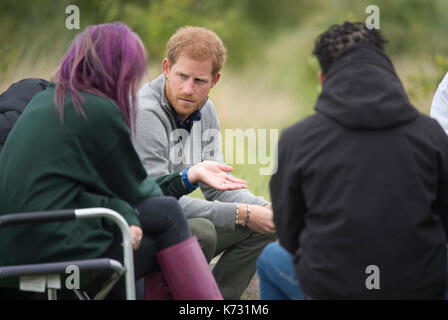 Prinz Harry Chats rund um ein Lagerfeuer beim Besuch der Chatham grünes Projekt, Naturschutz, Bildung und Nachhaltigkeit Initiative im Wilderness Foundation in Chatham Green, Essex. Stockfoto