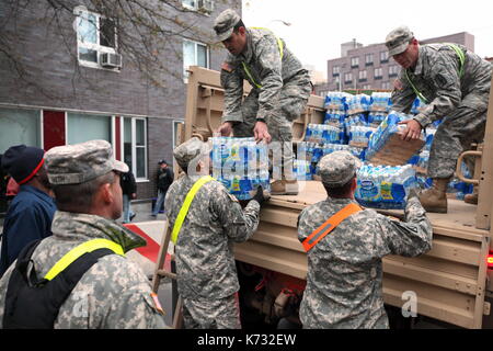 Truppen des nationalen Schutzes liefern Wasser und MREs (Mahlzeiten bereit zu Essen) zu einer Nächstenliebe distribution Station in der Nachmahd des Hurrikans Sandy in New York, N Stockfoto