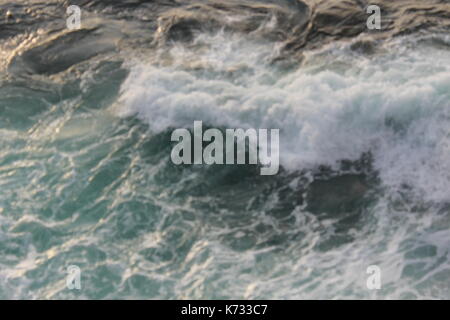 Wellen gegen das Ufer in San Sebastian mit einem stürmischen Meer. Stockfoto