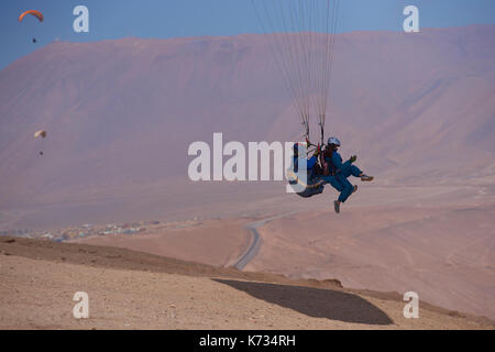 Tandem Paragliding über die Küstenstadt Iquique an der nördlichen Küste von Chile. Stockfoto