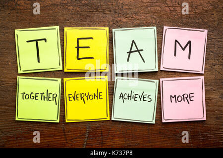 TEAM Akronym (zusammen Jeder erzielt mehr), Teamwork motivation Konzept, Handschrift auf einem bunten Haftnotizen gegen rustikalen, mit Holz Stockfoto