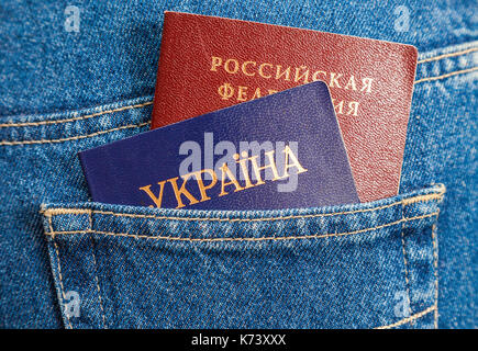 Russische und Ukrainische Pässe im Zurück jeans Tasche Stockfoto