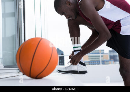 Bestimmt Basketballspieler Schnürsenkel binden Stockfoto