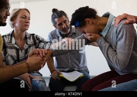 Freunde trösten. traurige Frau beim Sitzen im Kunstunterricht Stockfoto