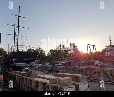 Alte Schiffe werden in Docks Sonnenuntergang repariert Stockfoto