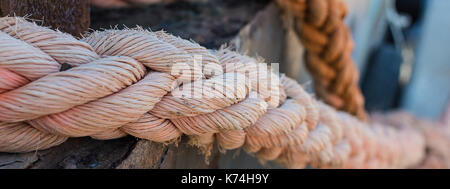 Seile auf alten rostigen Schiff closeup. alten ausgefransten Boot Seil als nautische Hintergrund. naval Seile auf einem Pier. Vintage nautische Knoten. große marine Schiff rop Stockfoto