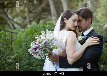 Romantisches Paar mit geschlossenen Augen umarmt, während in PARK-Stellung Stockfoto