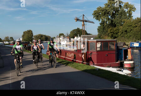 Gloucester & Stroudwater Canal an Saul Junction, Gloucestershire England UK. 2017. Gruppe der männlichen Radfahrer Radfahren auf dem Leinpfad. Stockfoto