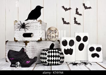 Rustikale schwarz und weiß Halloween Dekoration gegen einen weißen Holz Hintergrund Stockfoto