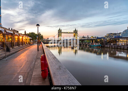 Beleuchtete Tower Bridge und deren Reflexion im klaren Wasser der Themse, London Stockfoto