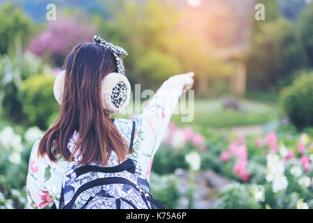 Frau schöne Mädchen auf etwas im Blumengarten. Stockfoto