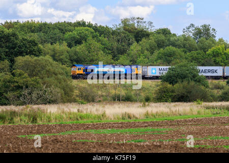 GBRf Klasse 66 (GB Railfreight). GBRf diesel Güterzug 66709 durch die britische Landschaft reisen, MSC Containerschiff auf der Seite lackiert Stockfoto