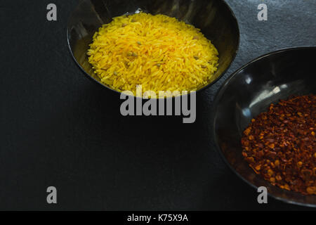 Close-up crushed Red Pepper und gelber Reis in der Schüssel Stockfoto