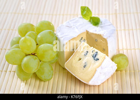 Französischer Camembert weichen Käse mit Trauben und marjorjam auf einem Holz- Tischset Stockfoto