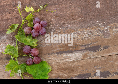 Strauß roter Trauben Links auf alten Vintage Holztisch Stockfoto