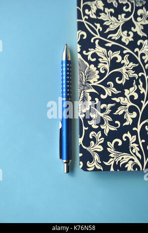 Florale notebook auf blauem Hintergrund mit blauen Stifte und Kopie Raum Stockfoto