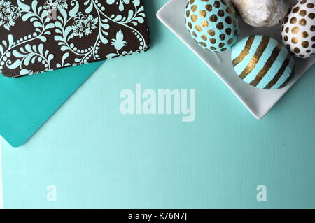 Verzierten Ostereier mit Blumen Notebook und Tasse Tee auf Mint aqua Teal Blue türkis Hintergrund mit Kopie Raum Stockfoto