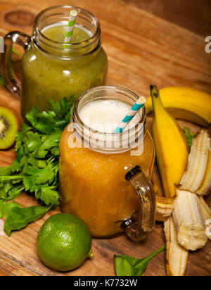 Sortiment von Obst und Gemüse Smoothies, die in Gläsern mit Strohhalmen auf Holz- Hintergrund. Stockfoto