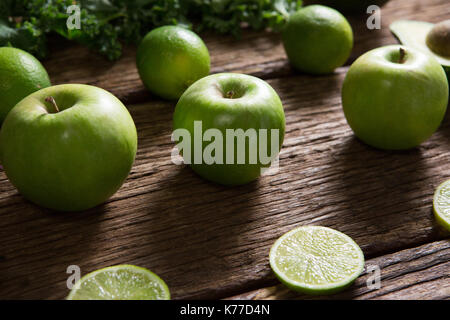 In der Nähe von grüner Apfel und Zitrone in Scheiben geschnitten auf hölzernen Tisch angeordnet Stockfoto