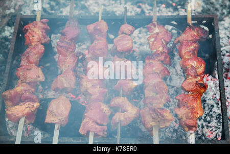 Marinierte Schaschlik vorbereiten auf ein Barbecue-Grill auf Holzkohle. Schaschlik oder Schaschlik in Osteuropa beliebt. Schaschlik aufgespießt Fleisch wurde ursprünglich Stockfoto