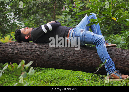 Junge Inder ruht auf Log Stockfoto