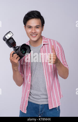 Junge asiatische Fotograf digitale Kamera halten, während der Arbeit im studio Stockfoto