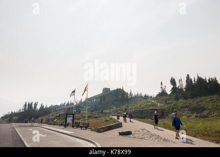 Touristische an der Vorderseite des Logan Pass Visitor Centre in den Smoky/dunstig Bedingungen in der Glacier National Park, die durch die Sprague wildfire Stockfoto