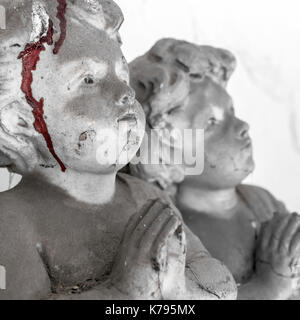 Statue von Kindern, mit Spinnweben bedeckt und getrocknetem Blut. Konzept von Kindesmissbrauch. Defokussierten verschwommenen Hintergrund. Stockfoto