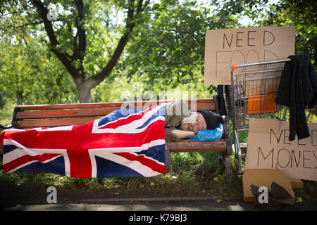 Schlafende obdachlose Menschen, die mit der Flagge. Stockfoto