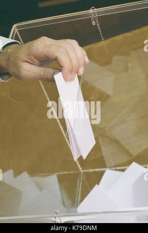 Bild von einer Urne und Hand eine leere Stimmzettel im Inneren, Wahlen, Abstimmungen Konzept. Stockfoto