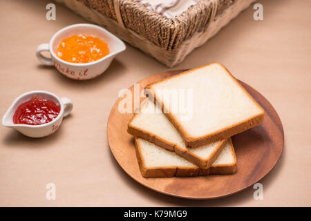 Toast mit Erdbeeren und orange Marmelade auf einem Teller auf den Tisch. Stockfoto