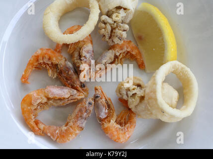 Gebratener Fisch mit Garnelen und einem gelben Zitronenscheibe Stockfoto